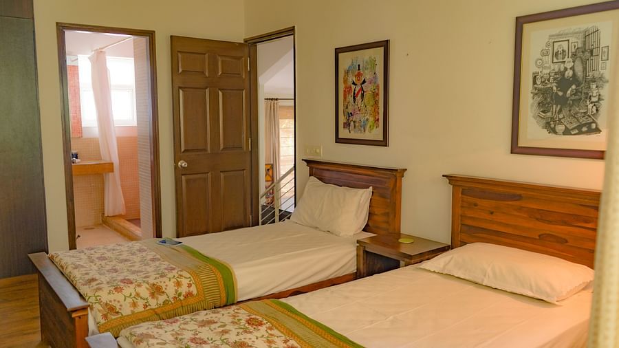 Single twin bed with bathroom door open at el benito goa