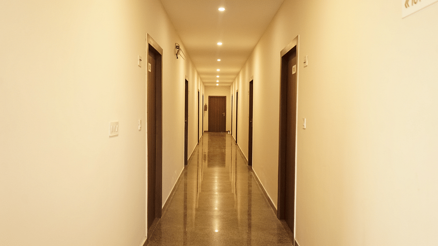 Corridor pathway leading to the rooms at Five Elements Hotels, Haridwar, illuminated by ceiling lights