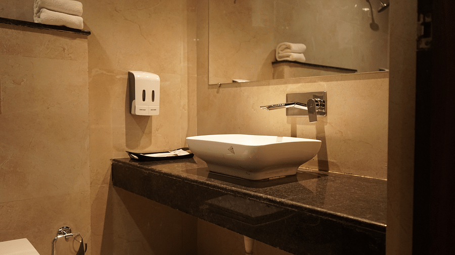 Washroom at Five Elements Hotels, Haridwar, featuring a sleek sink and a wall-mounted mirror for a modern and elegant touch