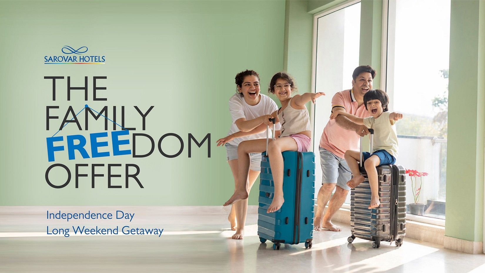  A joyous family with two children poses on suitcases, advertising Family Freedom Offer at Sarovar Hotels for an Independence Day long weekend