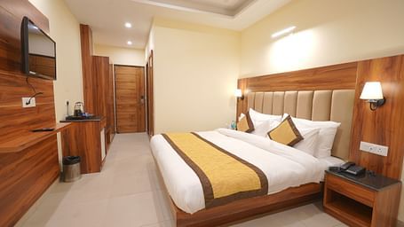 A large TV in front of the bed in Premium Room at DLS Oak Bush, Musssoorie.
