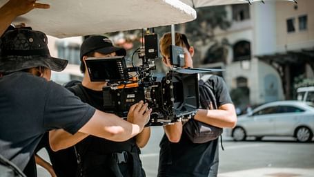 An image of three cameramen preparing the camera set up for a shoot