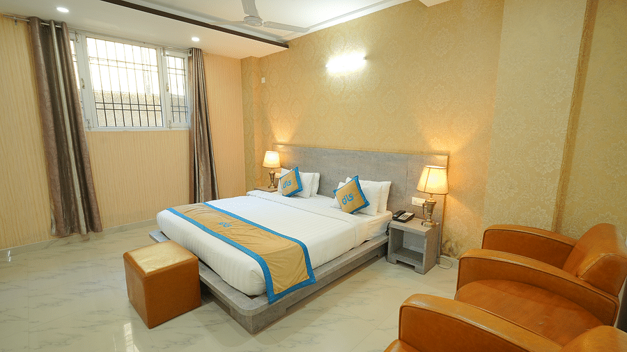 Image of the deluxe room featuring a king size bed, marble flooring and two couches | DLS Hotel Shiva Sanctuary & Spa, Dharamshala