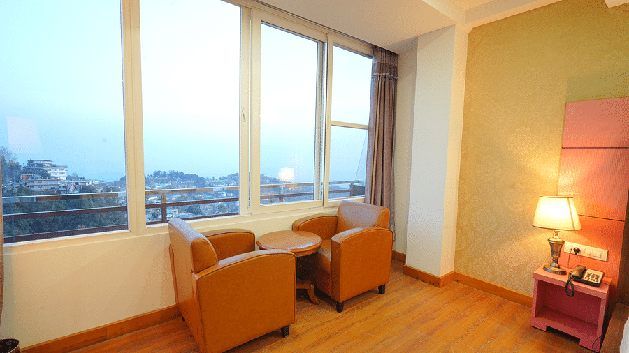 A cosy seating area in a hotel room with two armchairs and a small table | DLS Hotel Shiva Sanctuary & Spa, Dharamshala