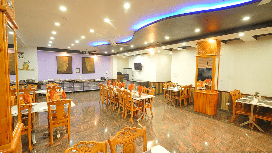 A long shot of the restaurant at the hotel featuring numerous tables and chairs | DLS Hotel Shiva Sanctuary & Spa, Dharamshala