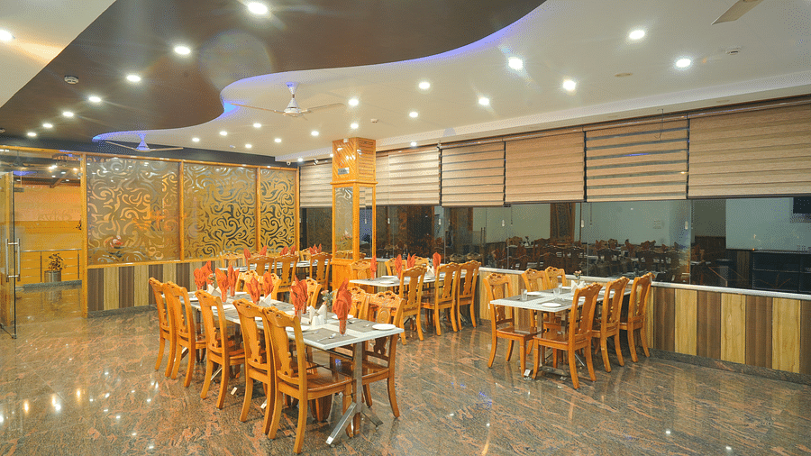 A large, well-lit restaurant with numerous tables and chairs and wooden accents | DLS Hotel Shiva Sanctuary & Spa, Dharamshala