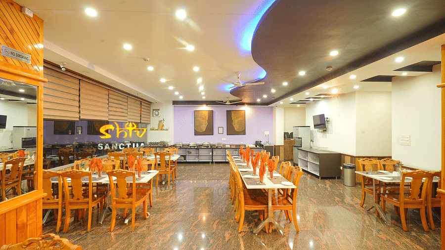 A wide angle shot of the dining area of the hotel with numerous tables and chairs | DLS Hotel Shiva Sanctuary & Spa, Dharamshala