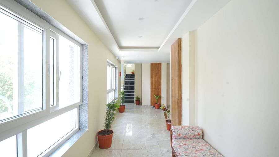 A hallway leading to the stairs with plants kept on either side at DLS Oak Bush, Mussoorie.