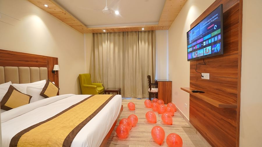 A large bed with TV on the opposite side in Deluxe Room at DLS Oak Bush, Musssoorie.