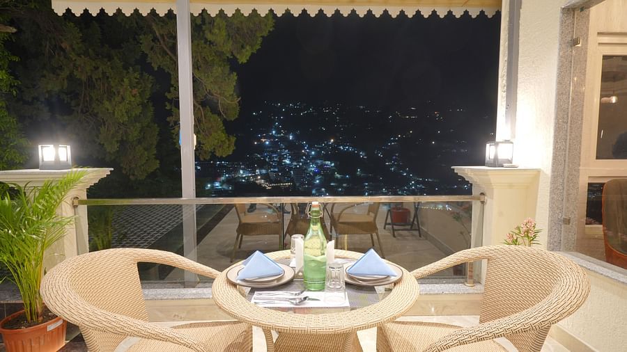 Dining seating area with scenic view at DLS Oak Bush, Mussoorie.