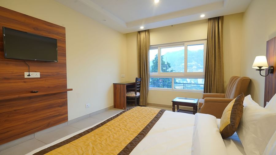 View from the bed of the TV and a large window at DLS Oak Bush, Musssoorie.