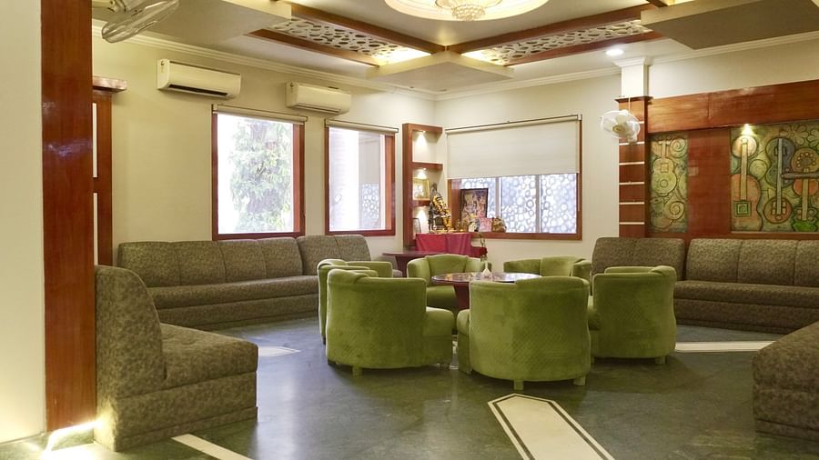 A hotel lobby with plush green sofas and armchairs arranged around a coffee table  | DLS Park Grace, Haridwar 