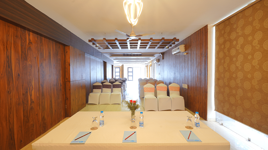 An image shot from the front of Whispering Wind Hall featuring a tables, chairs and bright lighting - DLS Whispering Winds