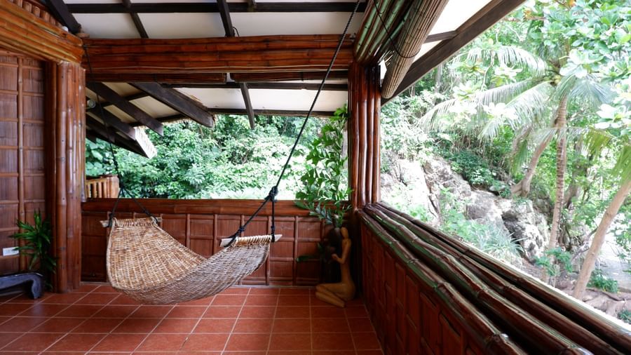 Private veranda with natural stone tub and lush jungle views at Flower Island Resort.