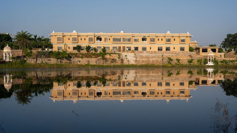 A water body reflecting a well structured building seen during an evening - Rajbagh Wellness, Udaipur
