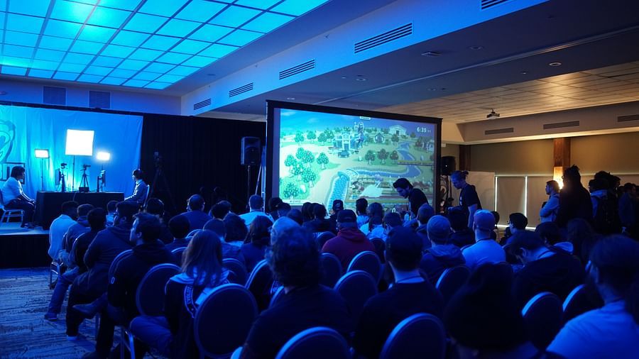 Image of a group of people seated in a conference room looking at the screen in front of them