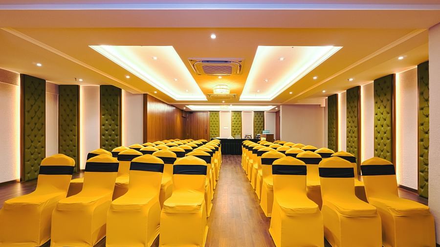 A huge room with neatly arranged chairs and a central presentation screen.