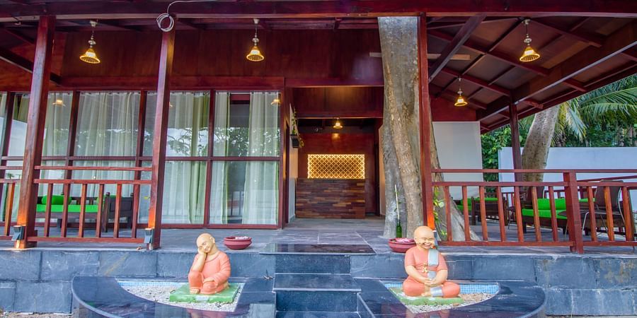 Statues at the entrance of Neil Ocean Spa that has wooden pillars - Symphony Summer Sand Beach Resort And Spa, Neil island