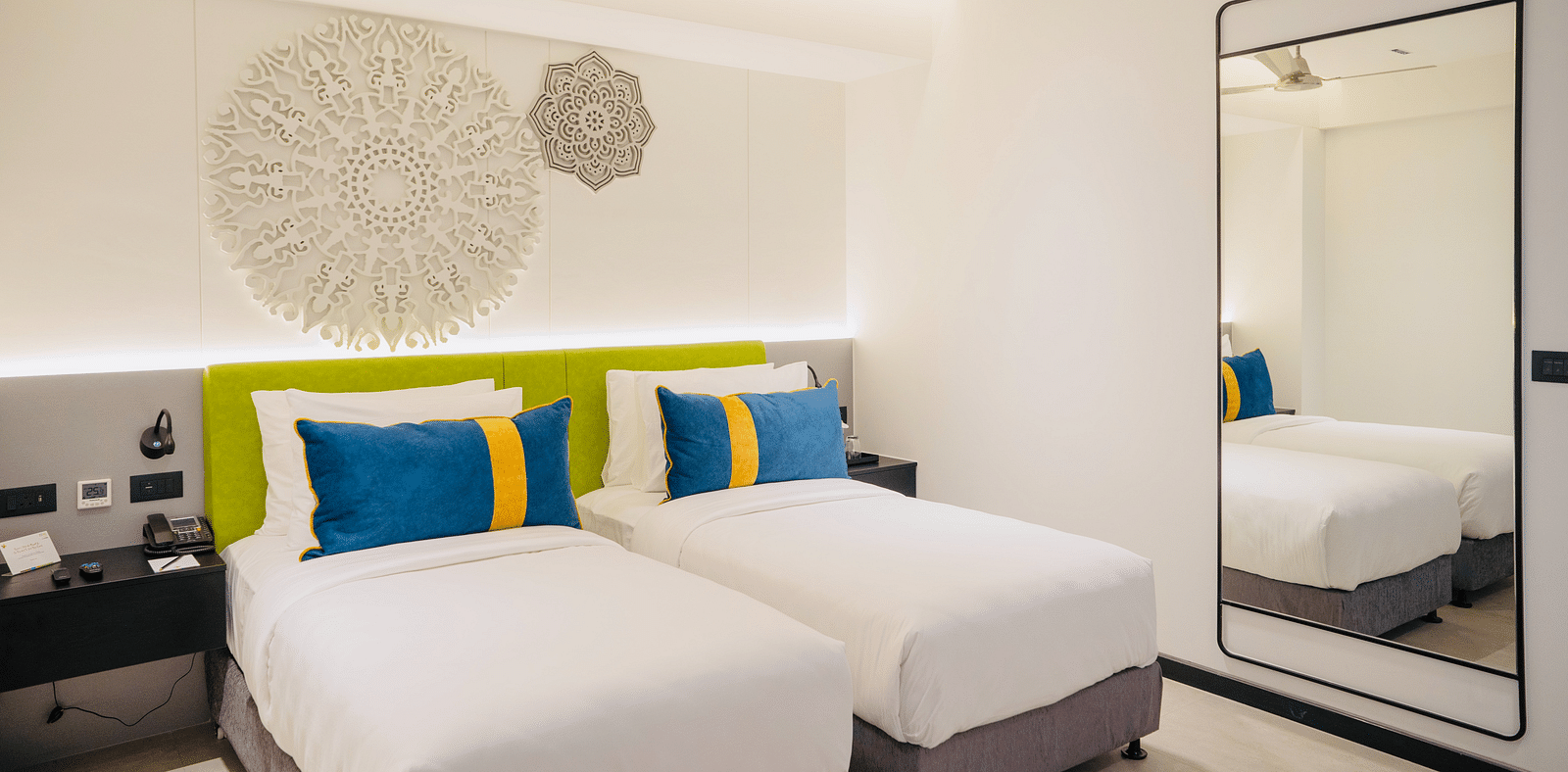 an image of the twin bedroom with well crafted headboard at Zibe Luxe Kakinada by GRT Hotels