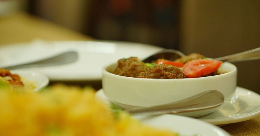 A close-up of Indian curry served in a bowl with garnish.