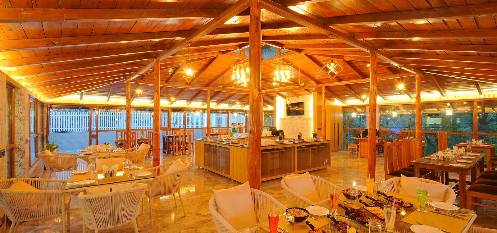 An image of a restaurant with bright yellow lighting and seating arrangement - DLS The Emerald, Nainital
