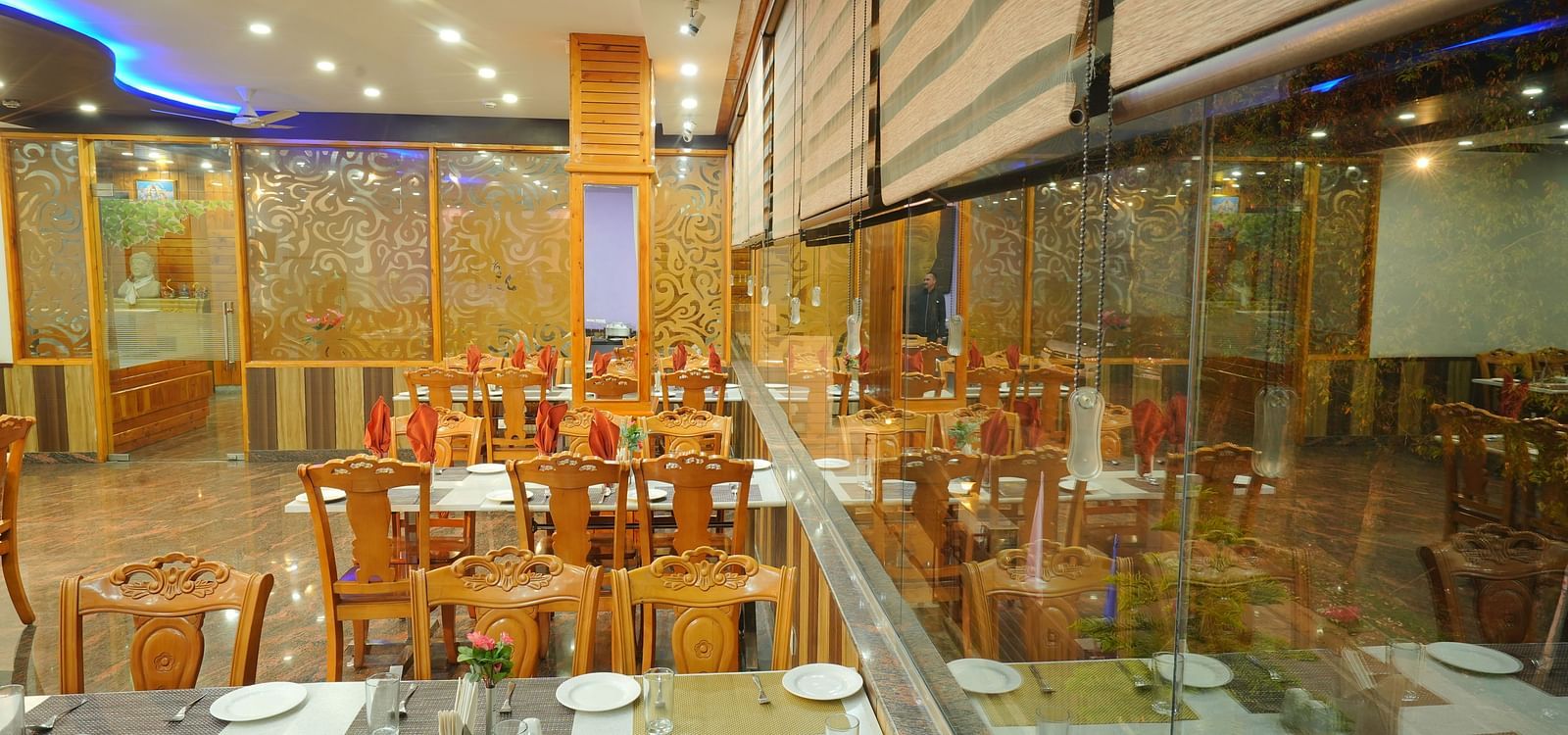 A closeup shot of the restaurant with several chairs and table arranged | DLS Hotel Shiva Sanctuary and Spa
