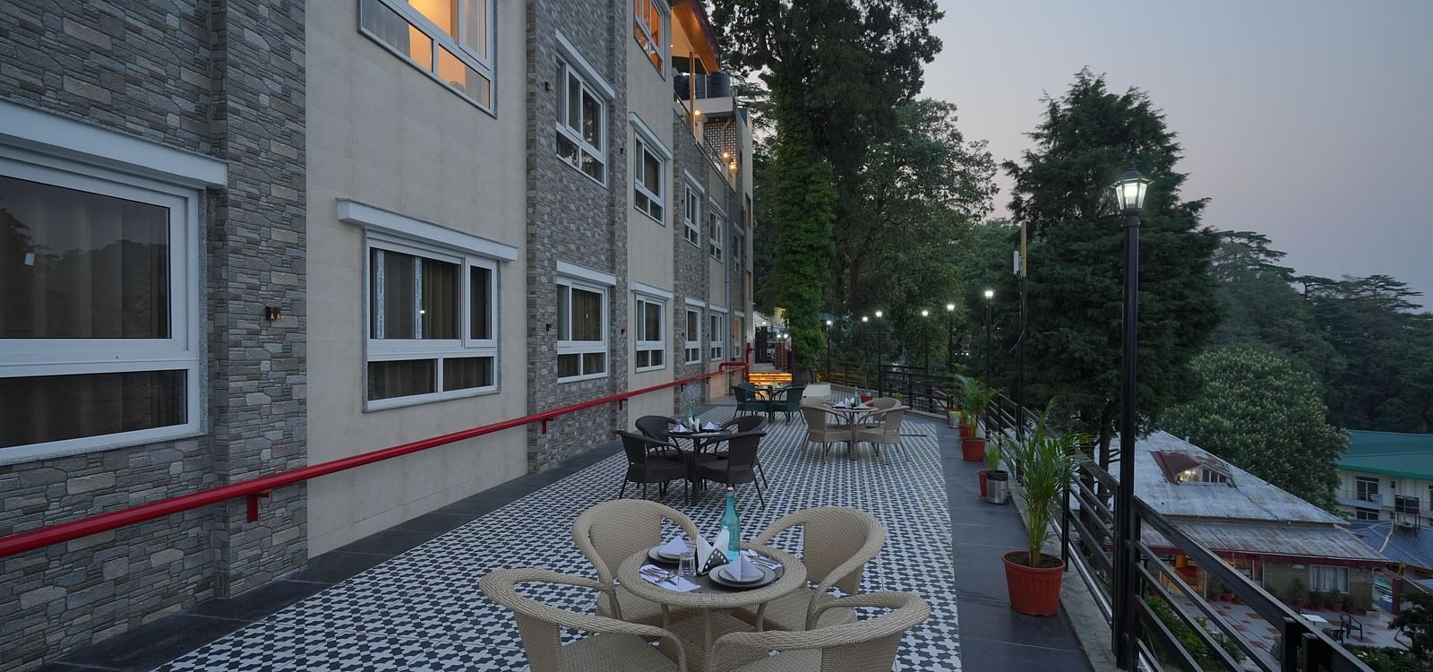 An outside seating area with comfortable chairs around tables at DLS Oak Bush, Mussoorie.