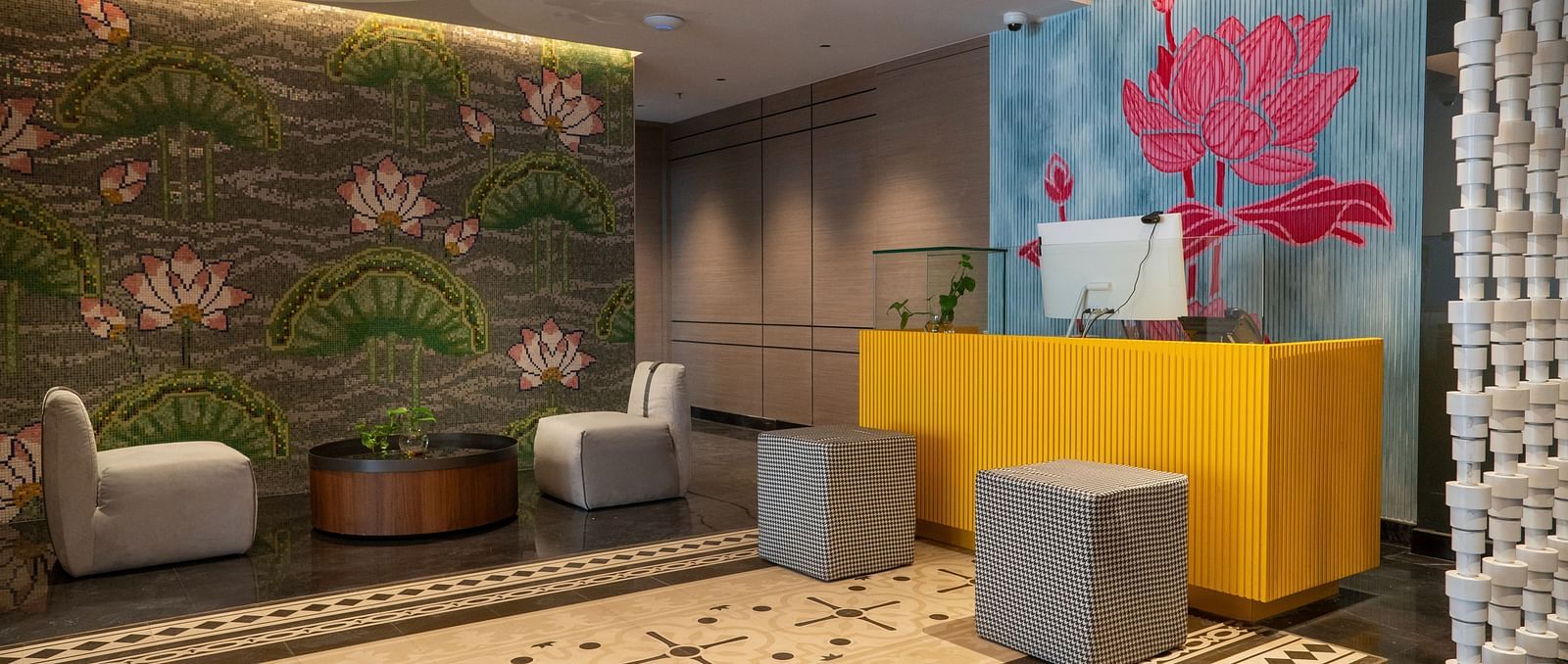 an image of reception area with flower wall paintings at Zibe Luxe Kakinada by GRT Hotels