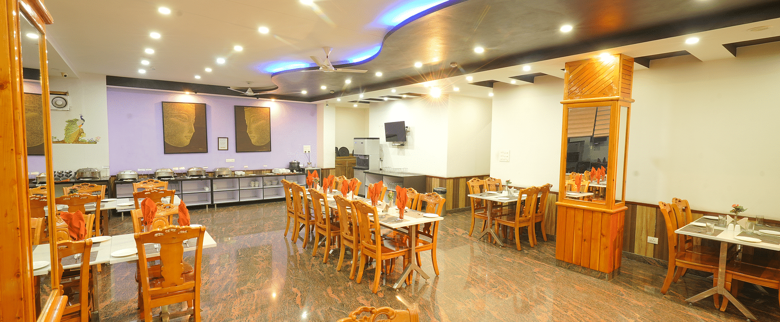 A long shot of the restaurant at the hotel featuring numerous tables and chairs | DLS Hotel Shiva Sanctuary & Spa, Dharamshala