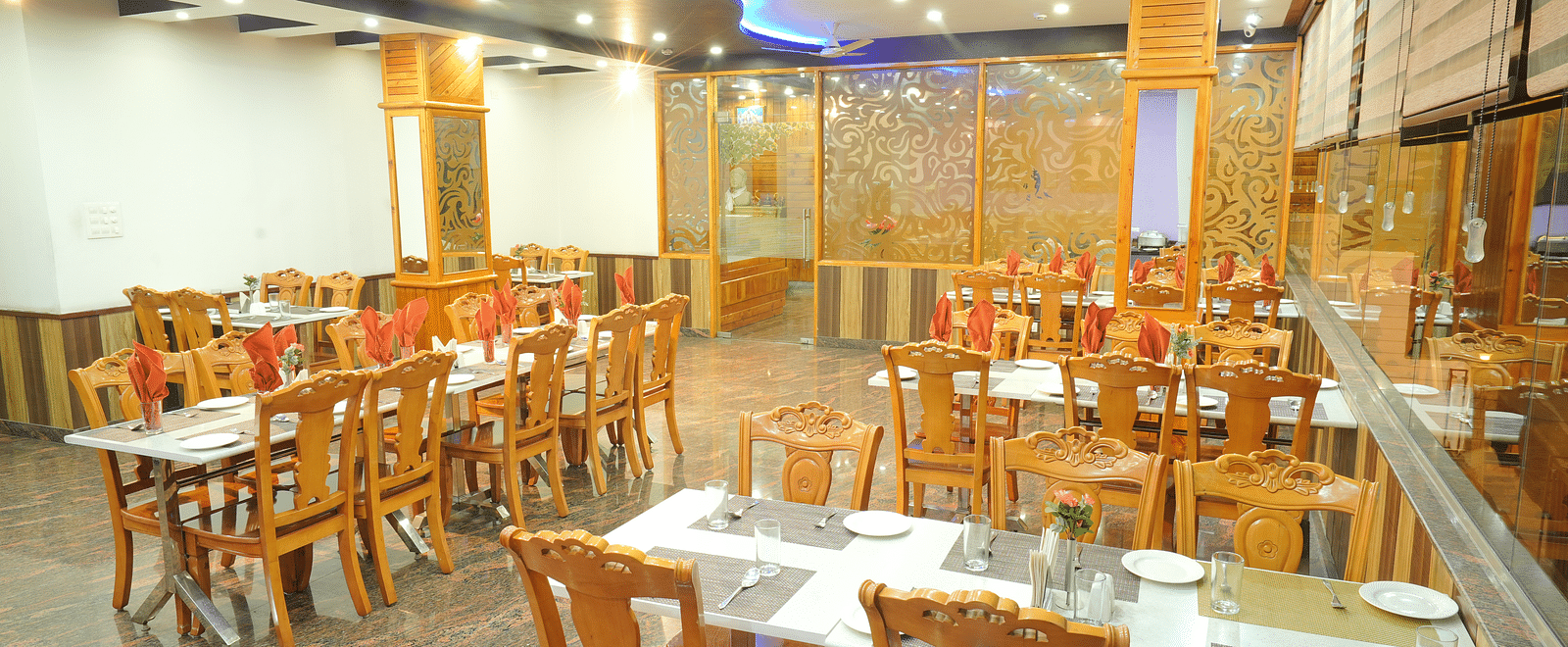 A close up shot of the restaurant with different table and chairs | DLS Hotel Shiva Sanctuary & Spa, Dharamshala