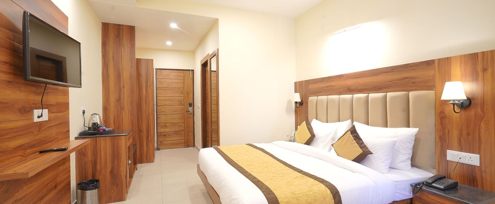 A large bed near a nightstand in Deluxe Room at DLS Oak Bush, Musssoorie.