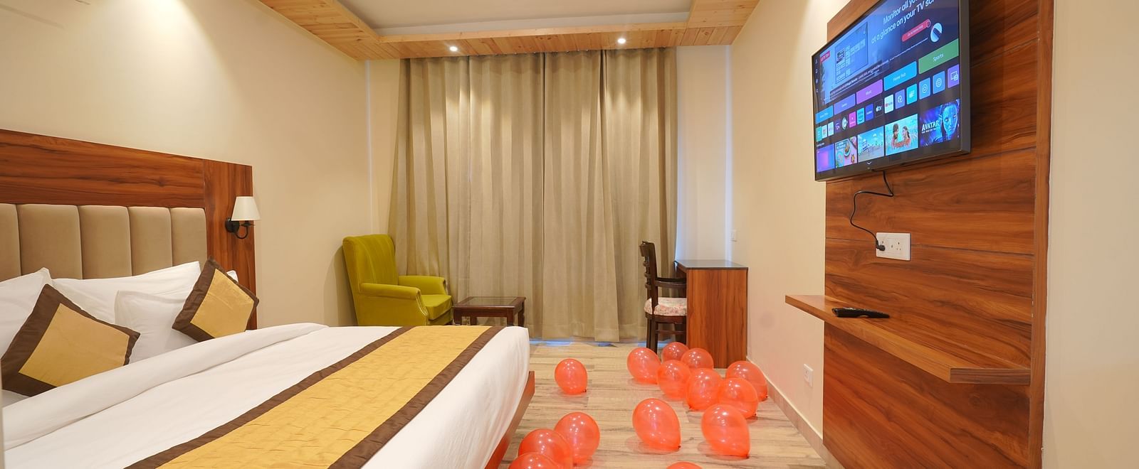 A large bed with TV on the opposite side in Deluxe Room at DLS Oak Bush, Musssoorie.
