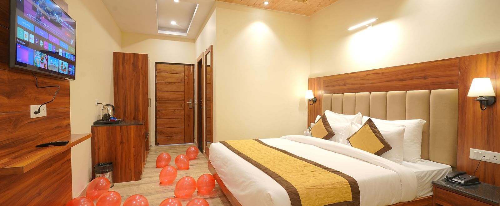 A large bed in front of the TV Deluxe Room at DLS Oak Bush, Musssoorie.