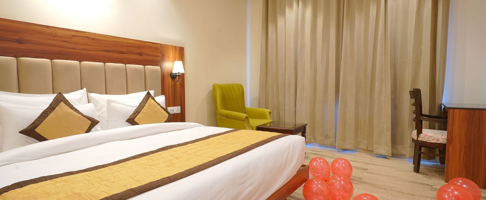 A large bed near a comfortable chair in Deluxe Room at DLS Oak Bush, Musssoorie.