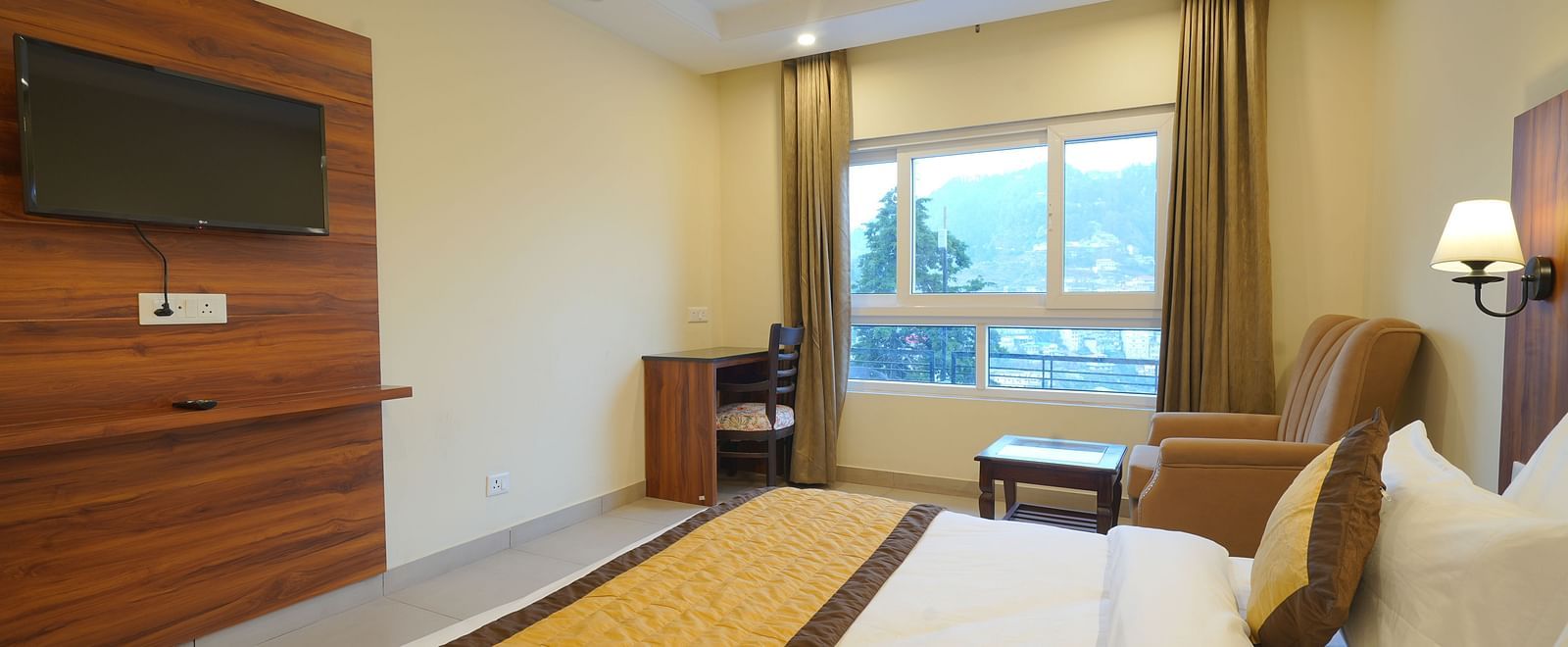 View from the bed of the TV and a large window at DLS Oak Bush, Musssoorie.