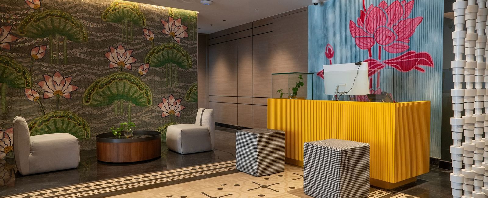 an image of reception area with flower wall paintings at Zibe Luxe Kakinada by GRT Hotels