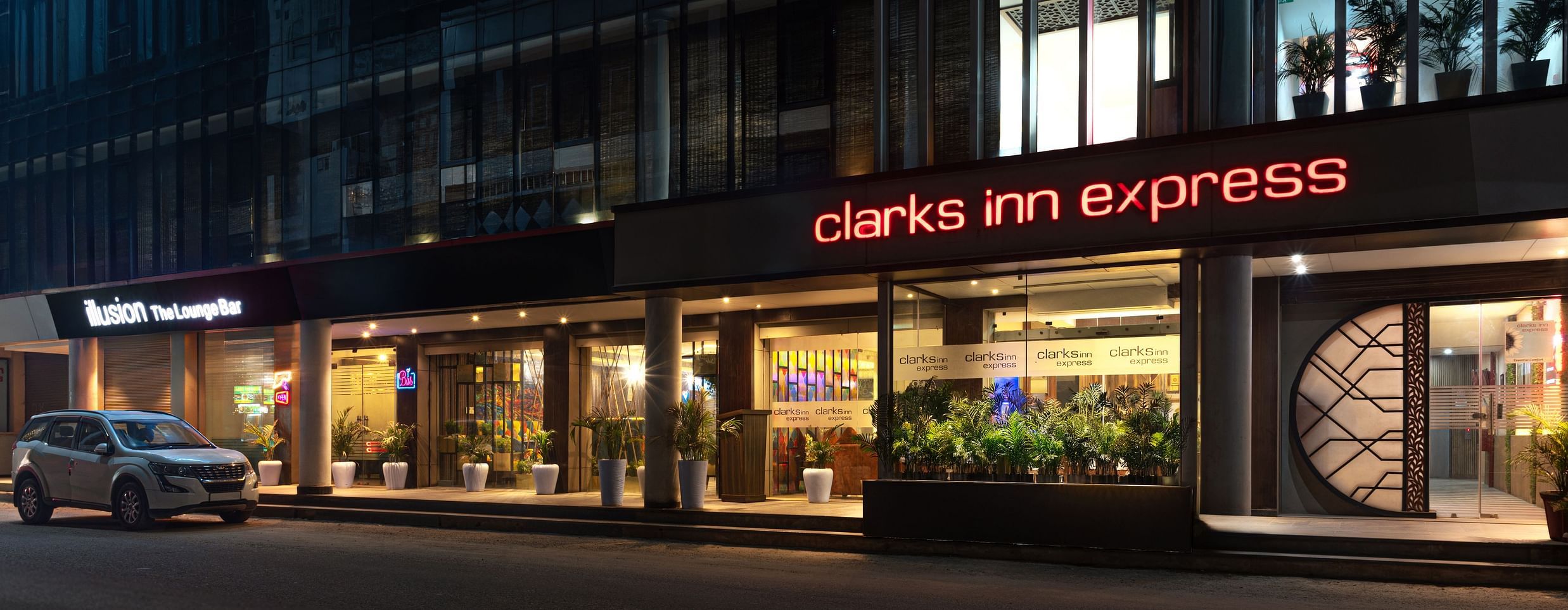  The exterior of  Clark Inn Express hotel with bright signage, showcasing its modern architecture and inviting entrance at night - Clarks Inn Express, Near Jammu Bari Brahmana Railway Station
