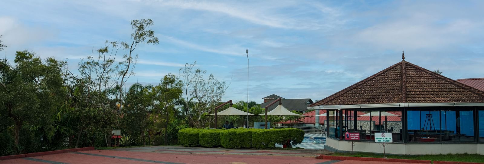 Tiled Floor with a house and greenery in the background | Woodstock Resorts, Coorg