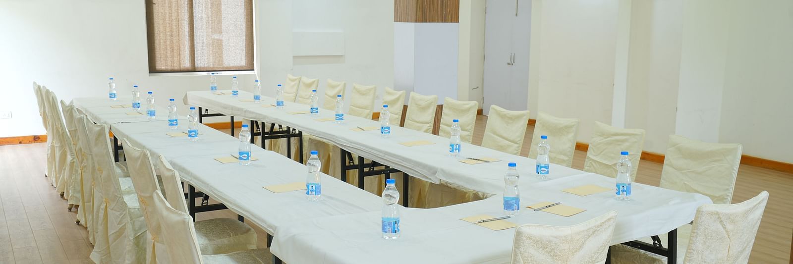 A large conference room with a long, rectangular table and chairs set up for a meeting | DLS Hotel Shiva Sanctuary & Spa, Dharamshala