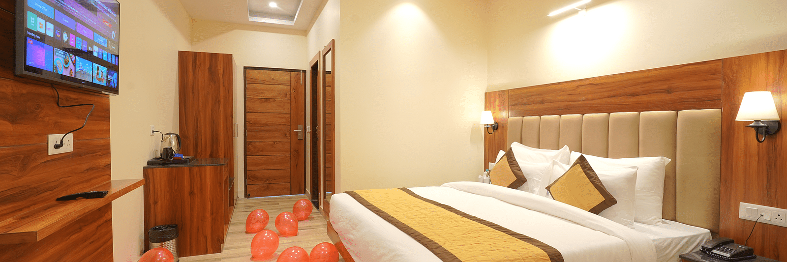 A large bed in front of the TV Deluxe Room at DLS Oak Bush, Musssoorie.