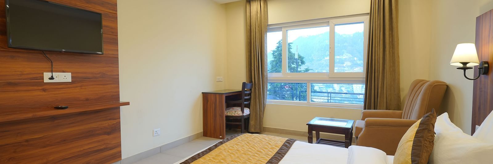 View from the bed of the TV and a large window at DLS Oak Bush, Musssoorie.