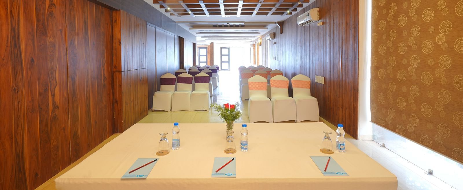 An image shot from the front of Whispering Wind Hall featuring a tables, chairs and bright lighting - DLS Whispering Winds