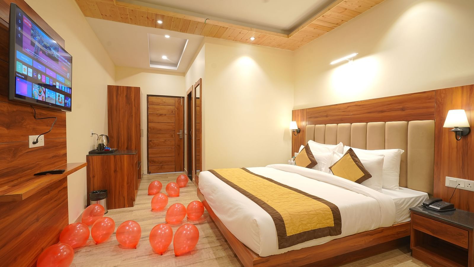 A large bed in front of the TV Deluxe Room at DLS Oak Bush, Musssoorie.