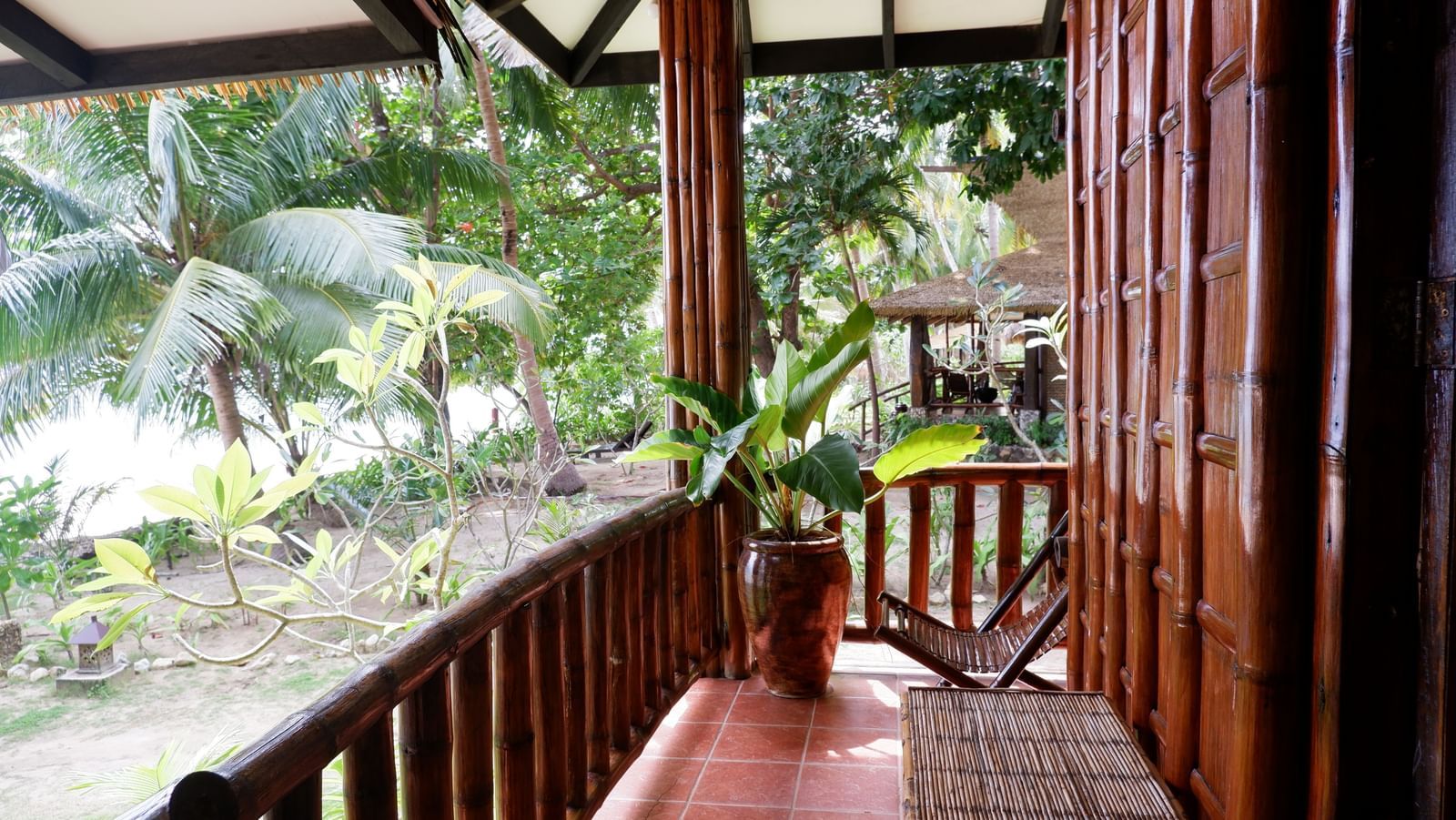 Cozy wooden balcony with tropical garden view at Flower Island Resort.