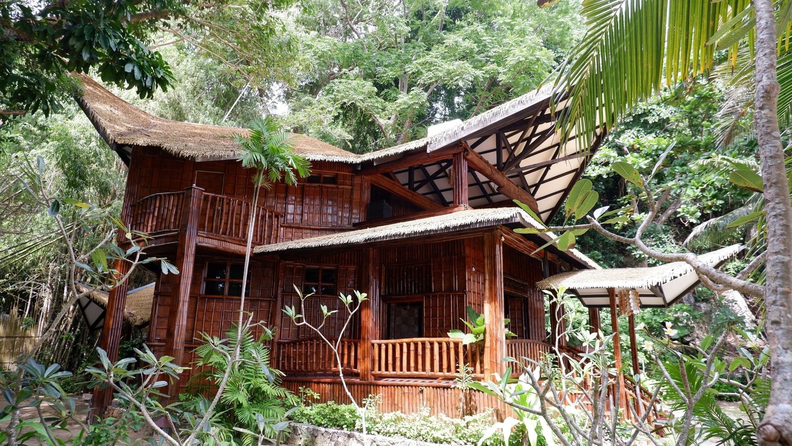 Rustic villa surrounded by lush greenery at Flower Island Resort.