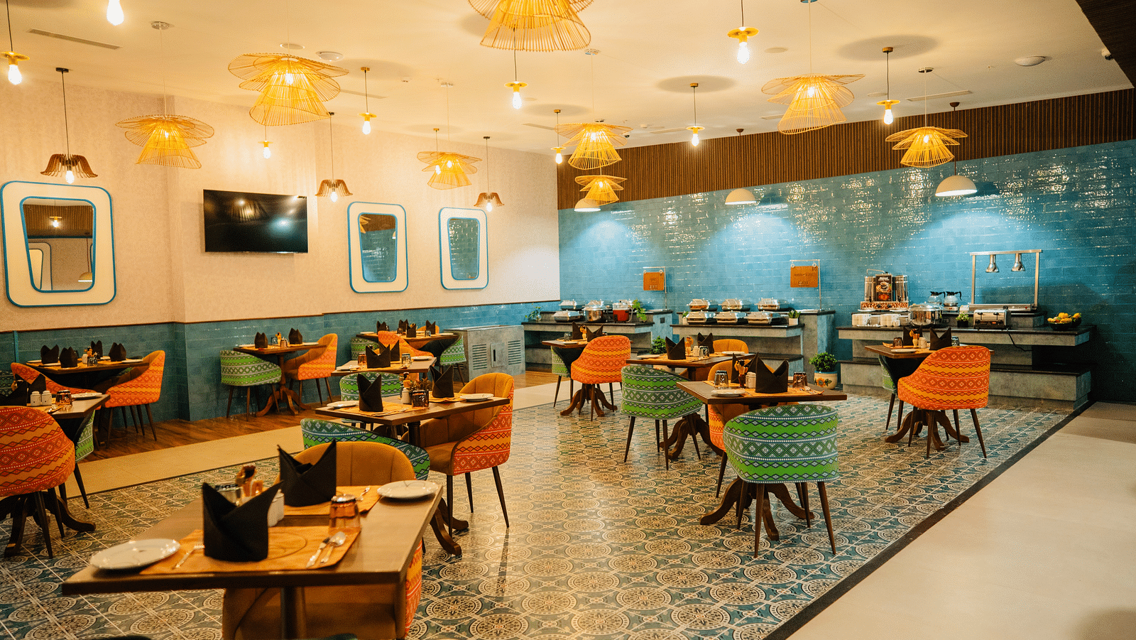 A dining area with chic hanging lights illuminating the table at Zibe Luxe Kakinada by GRT Hotels