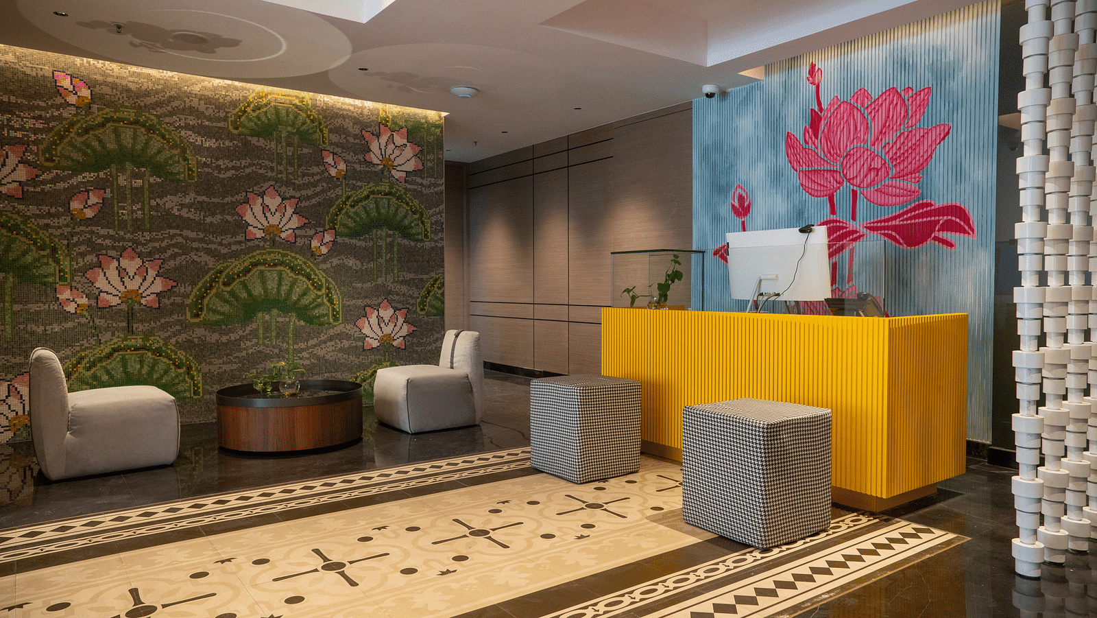 an image of reception area with flower wall paintings at Zibe Luxe Kakinada by GRT Hotels