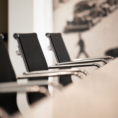 A conference room with a huge table surrounded by chairs on all sides.