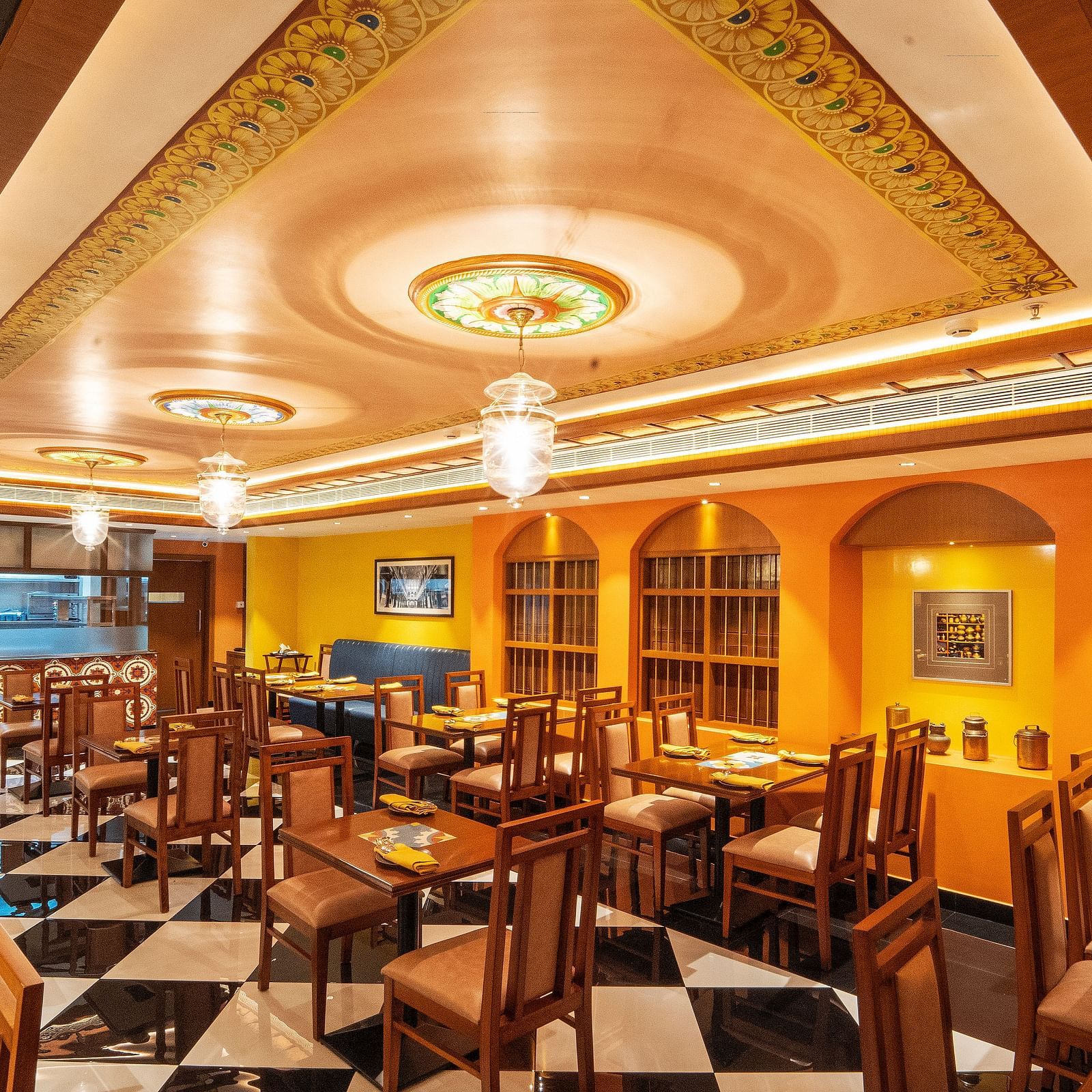 full view image of the chettinad stories dining area with bright chandeliers hanging from the ceiling