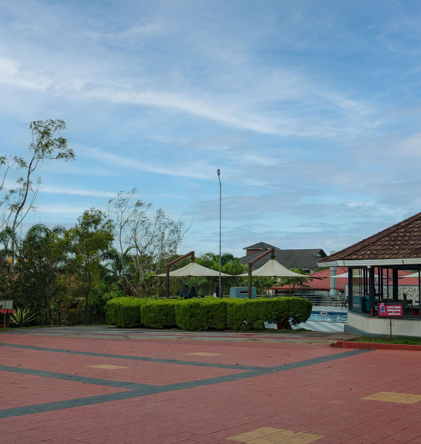 Tiled Floor with a house and greenery in the background | Woodstock Resorts, Coorg